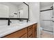 Modern bathroom features double sink vanity with white countertop, black fixtures, and walk-in shower at 2601 Gallarate Dr, Henderson, NV 89044
