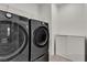 Modern laundry room featuring sleek, high-efficiency washer and dryer units with storage at 2601 Gallarate Dr, Henderson, NV 89044