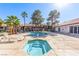 Community pool and hot tub with nearby lounge chairs and manicured desert landscaping at 2606 Durango Dr # 181, Las Vegas, NV 89117
