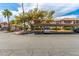 Exterior condo parking area with mature trees and landscaping, carports with parked truck and gate to residential complex at 2606 Durango Dr # 181, Las Vegas, NV 89117