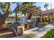 Outdoor barbecue area featuring a built-in grill and counter space, surrounded by lush landscaping at 2606 Durango Dr # 181, Las Vegas, NV 89117