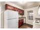 Kitchen with cherry cabinets, white appliances, and a window overlooking the backyard at 2606 Durango Dr # 181, Las Vegas, NV 89117