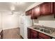 Kitchen with cherry cabinets, stainless steel sink, and modern fixtures at 2606 Durango Dr # 181, Las Vegas, NV 89117