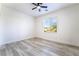 Well-lit bedroom with wood-style flooring, ceiling fan, and a window with bright natural light at 2651 Solera Moon Dr, Henderson, NV 89044