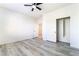Bright bedroom featuring a ceiling fan, closet, wood-style flooring and an entry door at 2651 Solera Moon Dr, Henderson, NV 89044