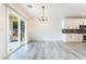 Light-filled dining area with sliding glass doors, modern chandelier, and open access to the kitchen at 2651 Solera Moon Dr, Henderson, NV 89044