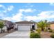 Inviting single-story home featuring desert landscaping, a spacious driveway, and an attached two-car garage at 2651 Solera Moon Dr, Henderson, NV 89044
