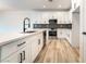Bright kitchen with white cabinets, stainless steel appliances, large center island and hardwood floors at 2651 Solera Moon Dr, Henderson, NV 89044