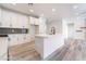 Bright, modern kitchen with white cabinets, gray backsplash, stainless steel appliances, and a center island with a sink at 2651 Solera Moon Dr, Henderson, NV 89044