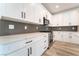 Well-lit kitchen featuring white cabinets, stainless steel appliances, gray backsplash, and quartz countertops at 2651 Solera Moon Dr, Henderson, NV 89044