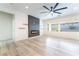 Bright living room featuring a modern fireplace, floating shelves, and large windows for natural light at 2651 Solera Moon Dr, Henderson, NV 89044