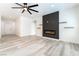 Open-concept living room with a contemporary fireplace, floating shelves, and stylish light wood flooring at 2651 Solera Moon Dr, Henderson, NV 89044