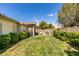 A vibrant backyard featuring lush green grass, trimmed bushes, and a dining area on a brick patio at 2780 Gallant Hills Dr, Las Vegas, NV 89135