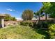 A lush green backyard with manicured landscaping, trees, and a patio set on the paver patio at 2780 Gallant Hills Dr, Las Vegas, NV 89135