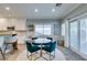 Bright dining area with a glass table, teal chairs, and sliding glass door leading to the outdoor space at 2780 Gallant Hills Dr, Las Vegas, NV 89135