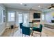Dining area with glass table, teal chairs, fireplace, TV, and sliding doors to backyard with pool at 2780 Gallant Hills Dr, Las Vegas, NV 89135