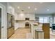 Modern kitchen with stainless steel appliances, white cabinets, and a breakfast bar leading to the dining area at 2780 Gallant Hills Dr, Las Vegas, NV 89135