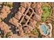 Aerial view of beautiful multi-unit homes featuring red tile roofs, lush landscaping, pool, and putting green at 30 Via Mantova # 109, Henderson, NV 89011
