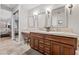 Bathroom featuring double vanity, wood cabinets, and a large mirror at 30 Via Mantova # 109, Henderson, NV 89011