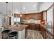 This kitchen has stainless steel appliances, wood cabinets, stone countertops, bar stool seating, and stylish pendant lighting at 30 Via Mantova # 109, Henderson, NV 89011