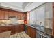 The kitchen has wood cabinets, granite countertops, stainless steel appliances, tile backsplash, and a stainless steel sink at 30 Via Mantova # 109, Henderson, NV 89011