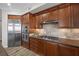 Modern kitchen with stainless steel appliances, granite countertops, and wooden cabinetry at 30 Via Mantova # 109, Henderson, NV 89011
