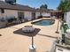 Backyard featuring a swimming pool, patio, a white rock fire pit, seating, and well-maintained landscaping at 3164 Elmrock Pl, Las Vegas, NV 89121