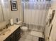 Traditional bathroom features a vanity with dark cabinets and a shower tub with a decorative curtain at 3164 Elmrock Pl, Las Vegas, NV 89121