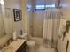 Traditional bathroom features a vanity with dark cabinets, a shower tub and decorative curtain at 3164 Elmrock Pl, Las Vegas, NV 89121