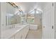 Bright bathroom featuring a tub, shower, stone floors and a large vanity with double sinks at 3165 S Monte Cristo Way, Las Vegas, NV 89117