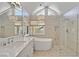 Bright bathroom featuring a tub, shower, stone floors and a large vanity with double sinks at 3165 S Monte Cristo Way, Las Vegas, NV 89117