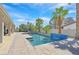 Sparkling pool with waterfall feature, lounge area, and lush landscaping in a serene backyard setting at 3165 S Monte Cristo Way, Las Vegas, NV 89117
