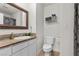 Bathroom with a toilet, sink with countertop, decorative mirror, and tile flooring at 4185 W Arby Ave, Las Vegas, NV 89118