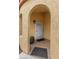 Inviting entryway with arched doorway, security screen door, potted plant, and neutral stucco exterior at 4185 W Arby Ave, Las Vegas, NV 89118