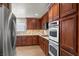 Well-equipped kitchen featuring stainless steel appliances, custom cabinets, stone counters and tile flooring at 4185 W Arby Ave, Las Vegas, NV 89118