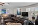 Spacious living room with a large brown leather sectional sofa and an art display with natural light from the windows at 4185 W Arby Ave, Las Vegas, NV 89118