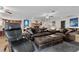 This living room offers dark leather furniture, an accent fireplace, and opens into the kitchen at 4185 W Arby Ave, Las Vegas, NV 89118