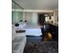 Modern bedroom with mirrored wall, white furniture, and dark wood floors at 4381 W Flamingo Rd # 3109, Las Vegas, NV 89103