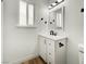 Bathroom vanity with black hardware, modern lighting, and wood-look flooring at 4432 Ash Ave, Las Vegas, NV 89110