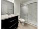 Modern bathroom features marble tile, sleek vanity, and sliding glass shower door at 4432 Ash Ave, Las Vegas, NV 89110