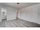 Bedroom with white walls, stylish gray wood floors and the bathroom in the background at 4432 Ash Ave, Las Vegas, NV 89110