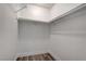 A well-lit walk-in closet features neutral walls, wood flooring, and a rack for hangers at 4432 Ash Ave, Las Vegas, NV 89110