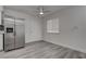 Open-concept living room with updated kitchen featuring stainless steel fridge, ceiling fan, and window at 4432 Ash Ave, Las Vegas, NV 89110