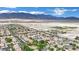Wide aerial view of a community with green spaces, homes, and scenic mountain views in the background at 4909 Cherokee Run Ct, Las Vegas, NV 89131