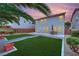 Backyard with manicured artificial lawns, desert landscaping, and patio furniture, perfect for relaxing at 4909 Cherokee Run Ct, Las Vegas, NV 89131