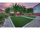 Lush backyard featuring artificial grass, potted palms, desert landscaping and privacy fence at 4909 Cherokee Run Ct, Las Vegas, NV 89131