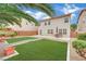 Large backyard features artificial turf, patio, desert landscaping, and seating, perfect for entertaining guests at 4909 Cherokee Run Ct, Las Vegas, NV 89131