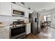 Kitchen and dining area featuring granite countertops, stainless steel appliances, and wood floors at 504 Crony Ave, Henderson, NV 89011