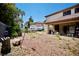 Wide angle of the backyard with a patio area, greenery, and recreational vehicle parking at 5412 Rainbows End Dr, Las Vegas, NV 89149