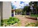 Wide angle view of the backyard with patio, garden bed, and lush landscaping at 5412 Rainbows End Dr, Las Vegas, NV 89149